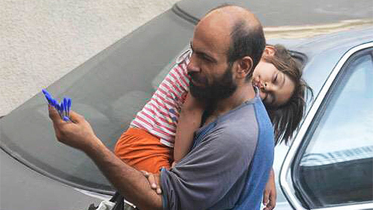 Una foto viral de un refugiado con su hija en brazos recauda miles de dólares de ayuda