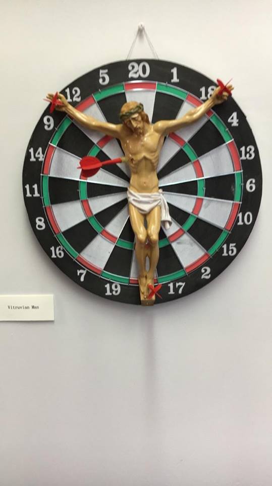 Pieza de arte con Jesús crucificado en una diana de tiro al blanco es retirada de exposición