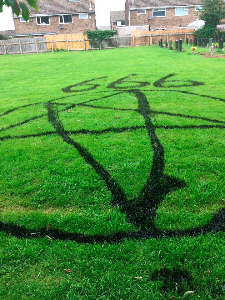 Dibujan símbolos satánicos en el patio de un cementerio durante el día del padre