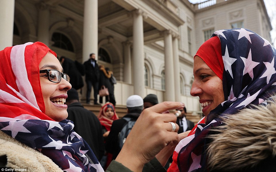 Neoyorquinos usan banderas de estados unidos sobre sus cabezas en solidaridad con mujeres musulmanas