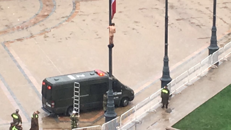 Hombre desnudo trepa mástil en Plaza de la Constitución: cayó sobre bus de Carabineros