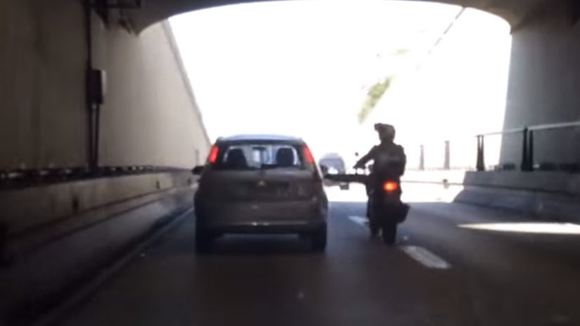 (VIDEO) Hombre pateó un auto desde su moto en marcha y casi se mata