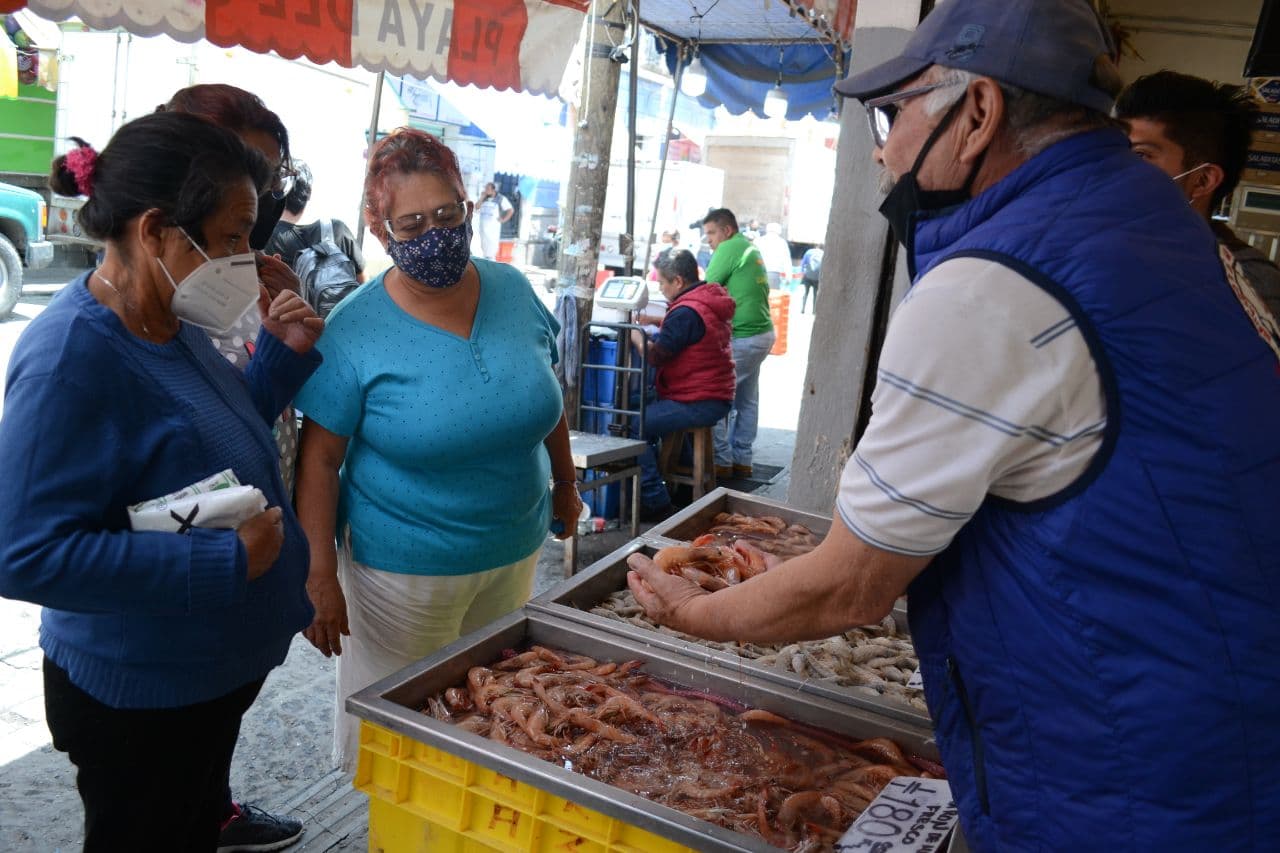 Gente comprando alimentos en un mercado de Puebla