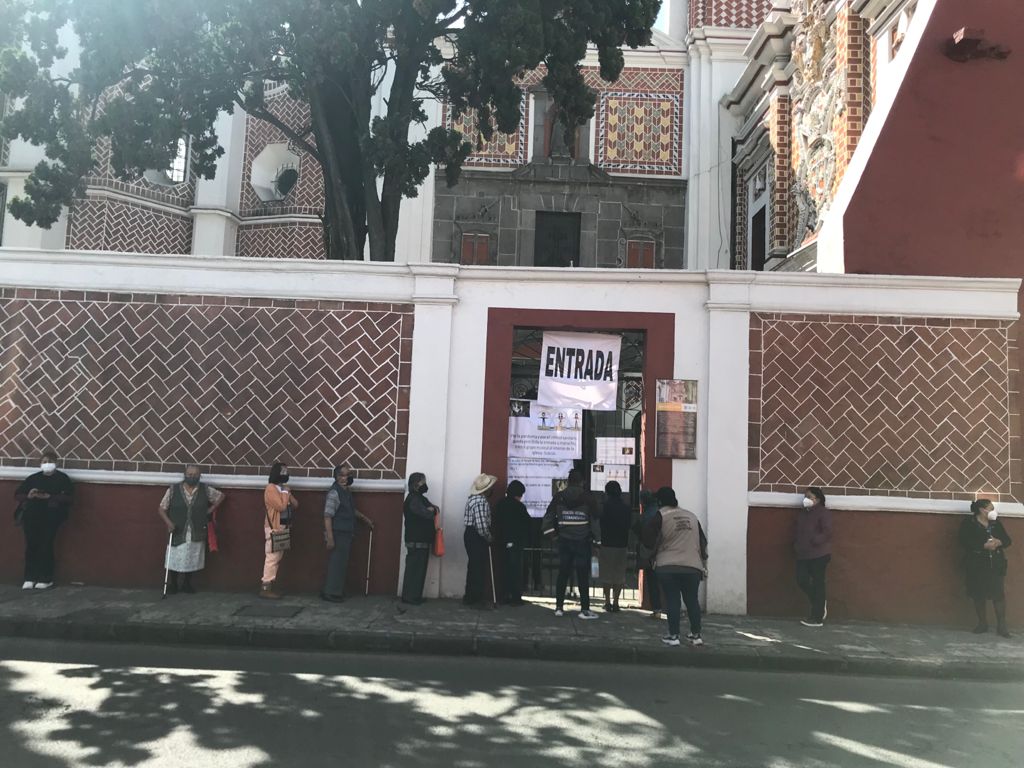 Gente formada esperando poder entrar a la iglesia de El Carmen