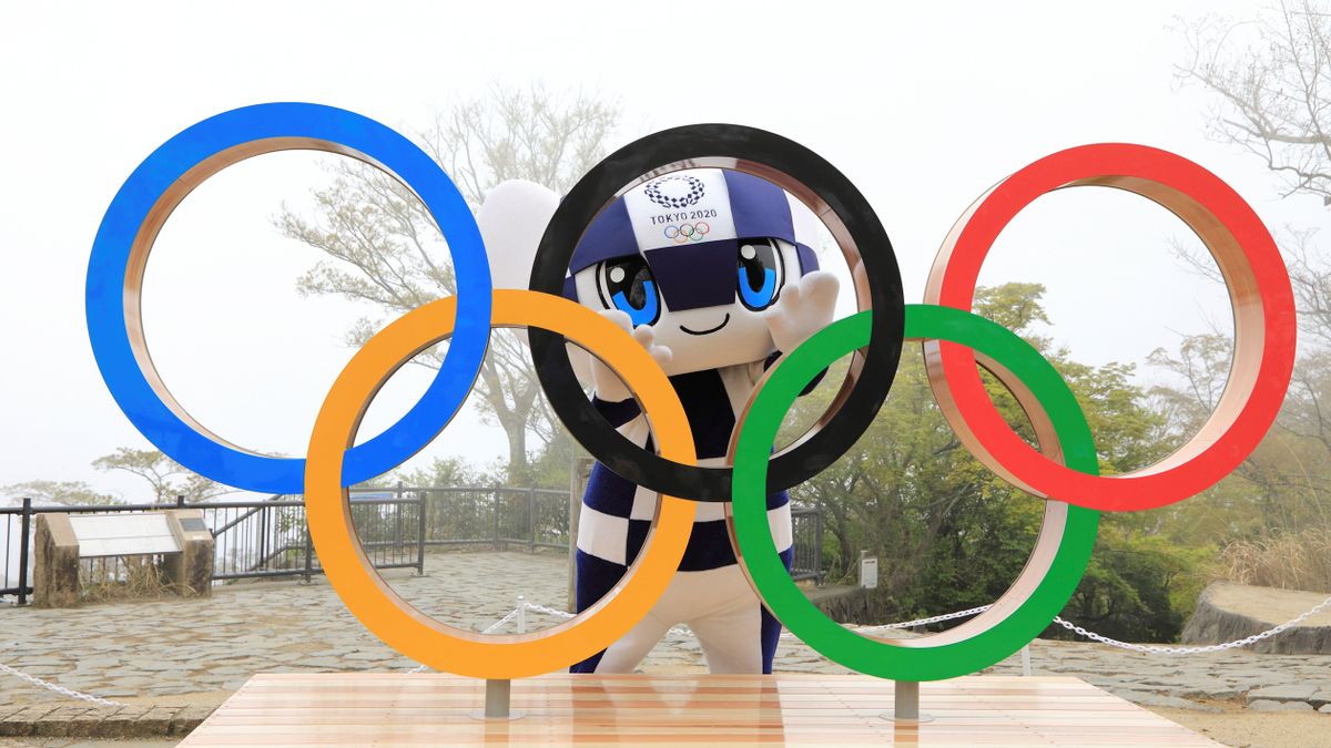 Se ven los cinco aros de los juegos olimpicos y en el medio de uno la mascota de los juegos olimpicos tokio 2020