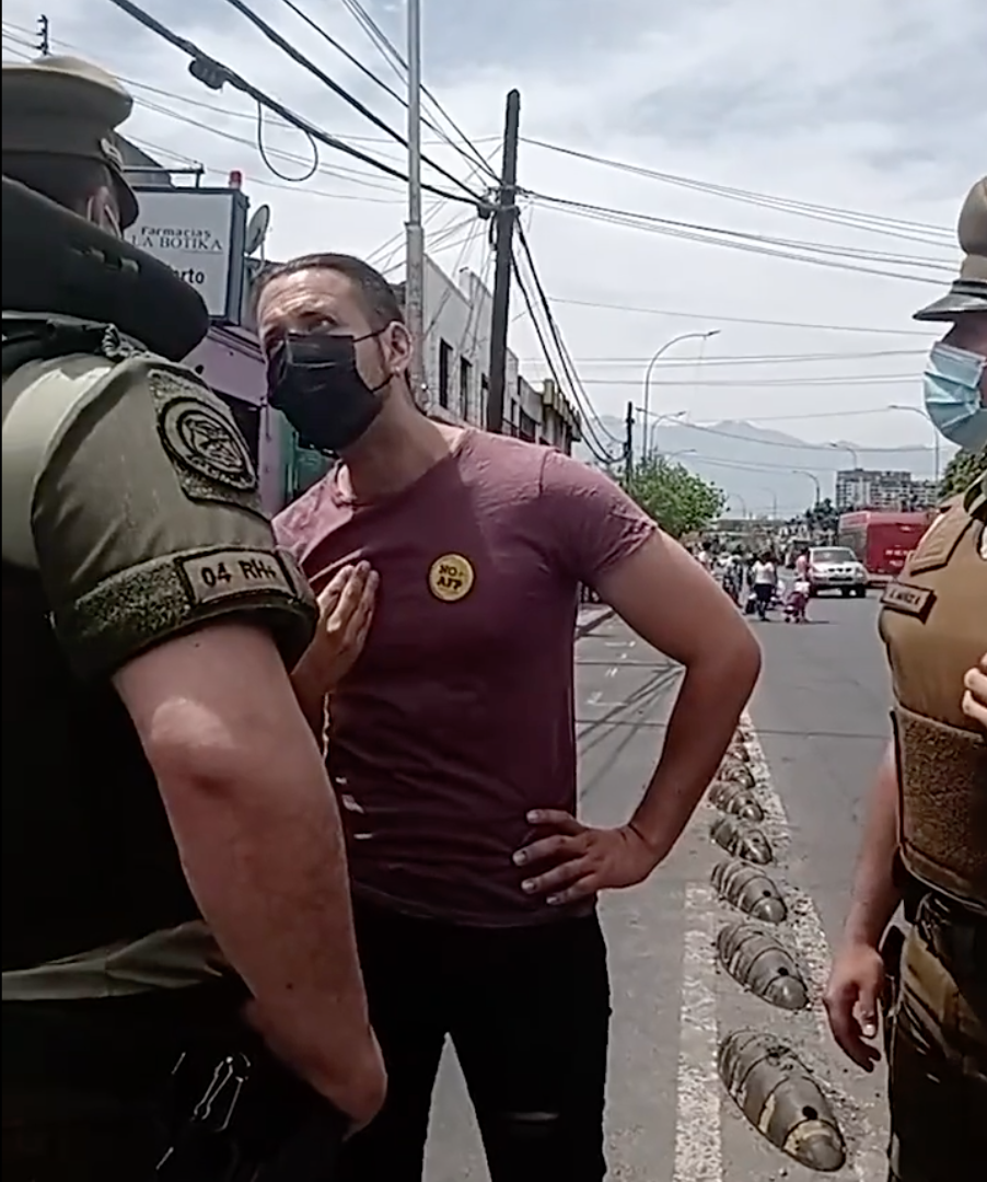 Con empujones e intentos de detención, carabineros escoltas de Sichel expulsan a Andrés Giordano (D9) de actividad por llevar chapita de «NO+AFP»