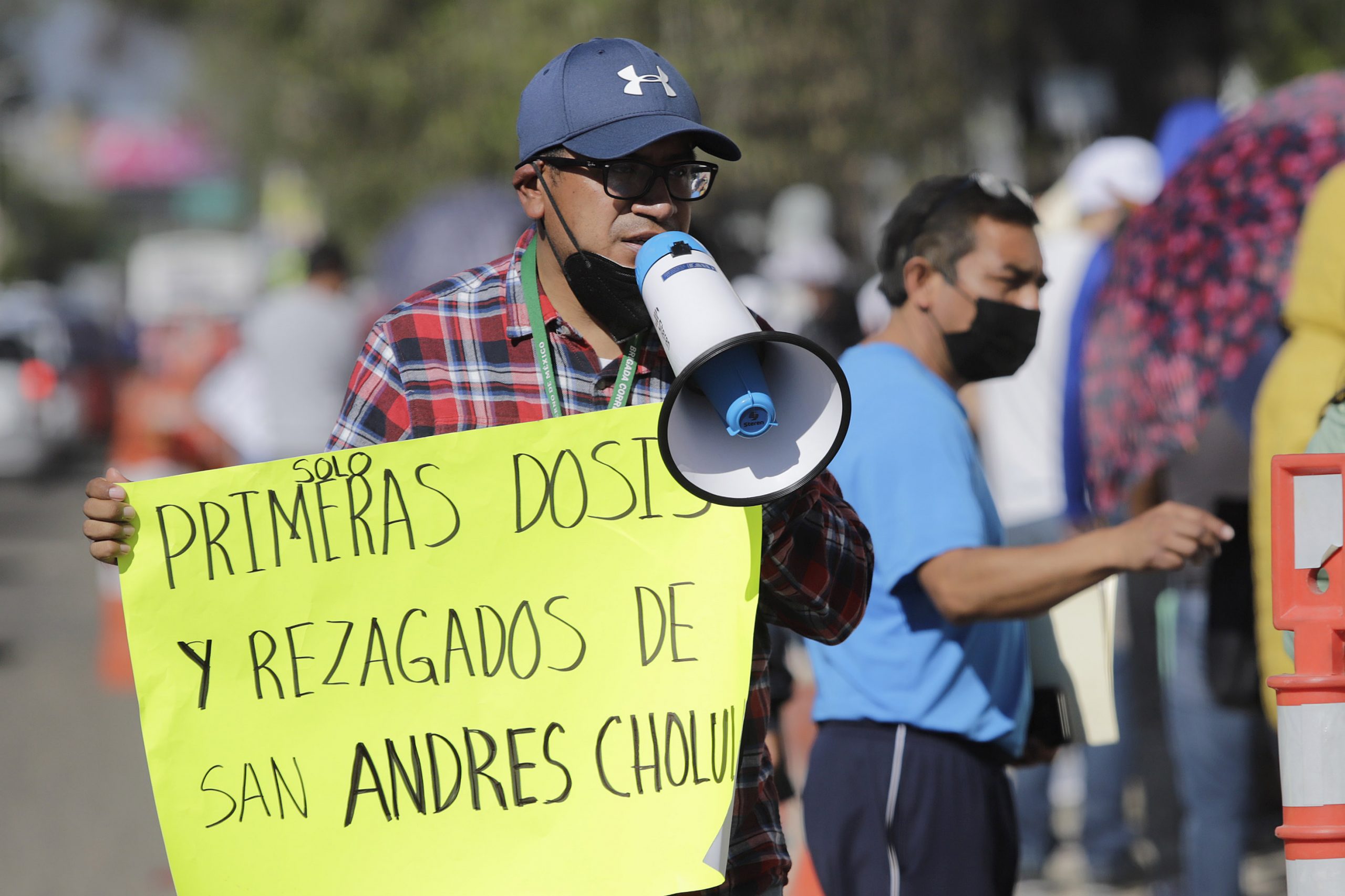 Señor con cartel de vacunación para rezagados