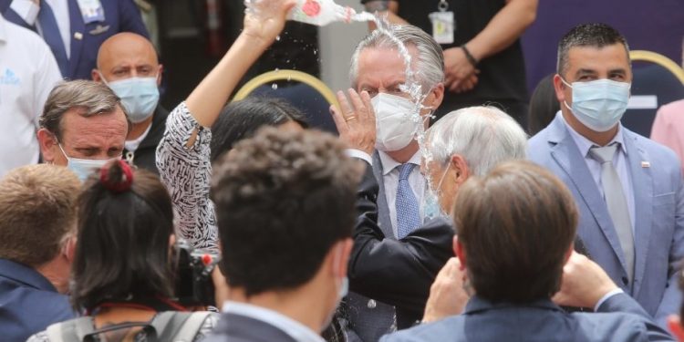 Mujer vacía botella de agua en la cabeza a Piñera durante acto en La Moneda