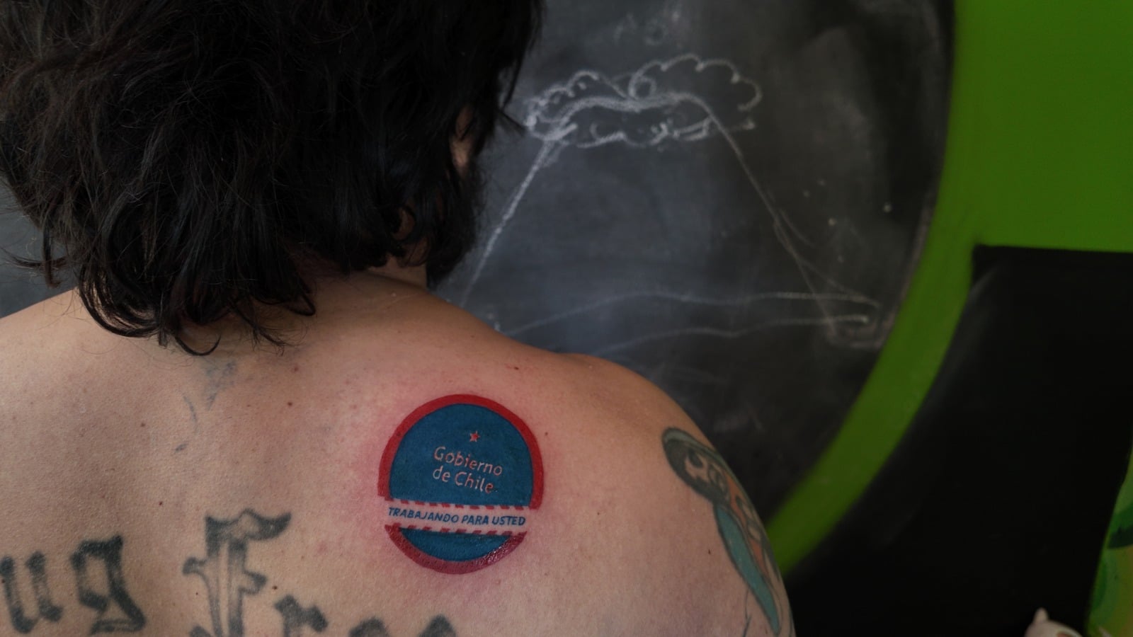 Artist Francisco Tapia Engages with ‘Working for You’ by Tattooing Government’s Rejected Logo